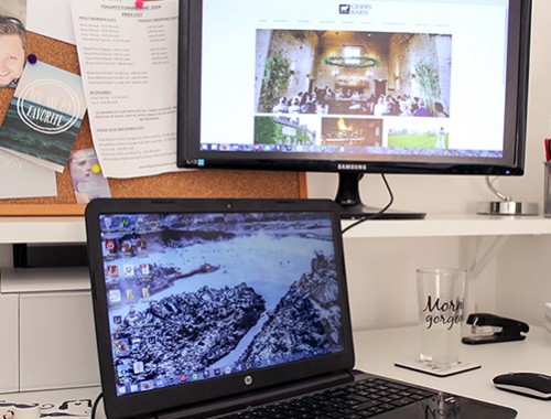 My office; laptop with a background image of Iceland and second monitor with Cripps Barn website